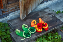 Two Pairs Of Dwarf Felt Shoes At The Entrance Of An Old Wooden House. Dwarves Came To Visit