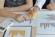 © Puwasit Inyavileart - Financial and investment planning, Head of Marketing is analyzing data from the summary graph statistics for executives, business meetings.