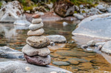 Fototapeta Desenie - Cairn of balanced stones by the riverside of the wairere stream near Whakapapa in New Zealand