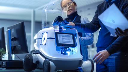 Wall Mural - close-up shot of a robot in a modern laboratory/ research center. multi ethnic team of male and fema