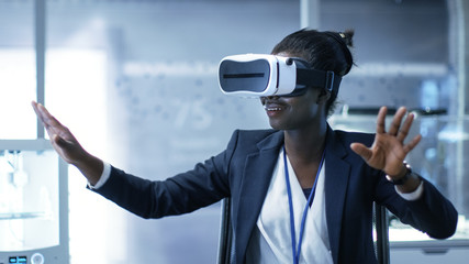 Wall Mural - young black female virtual reality engineer/ developer wearing vr headset creates content. she's alo
