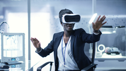 Wall Mural - young black female virtual reality engineer/ developer wearing vr headset creates content. she's alo
