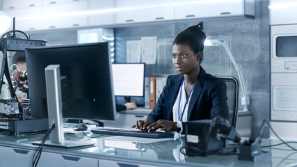 Wall Mural - black female scientist working on a computer with her colleagues at research center.