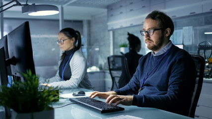 Wall Mural - caucasian male and female engineers working on a computers in a bright modern high-tech laboratory.
