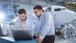© Gorodenkoff - Two Aircraft Mechanics Working and Having Conversation next to Laptop Computer