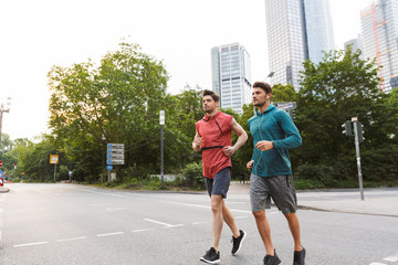 Poster - Photo of two athletic young men doing workout and running on city street