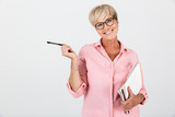 Fototapeta  - Portrait of blond adult woman wearing eyeglasses holding studying books and pen