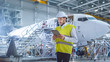 © Gorodenkoff - Aircraft Maintenance Mechanics Moving through Hangar. Holding Tablet Computer