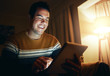 © StratfordProductions - Close-up of a man using digital tablet till late at night in home