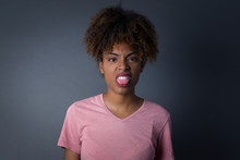 Body Language. Disgusted Stressed Out Pretty African American Girl With Curly Fair Hair Posing Against Gray Wall, Frowning Her Face, Demonstrating Aversion To Something.