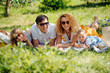© zzzdim - Family picnic on grass in the gardens under gentle shade of trees