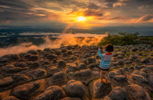 Asian Girls Take Pictures Of Beautiful Sunsets At The Highest Point Of Phu Hin Rong Kla National Park And The Rock Fields On The Northern Summit Of Thailand.