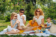© zzzdim - Family picnic on grass in the gardens under gentle shade of trees