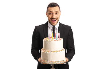 Sticker - Excited young man in a suit holding a cake with candles and smiling