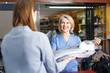 © JackF - Worker giving woman her clean clothes