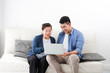 © chayathon2000 - Asian young man and senior woman using laptop computer in living room concept Son teach mother use computer laptop