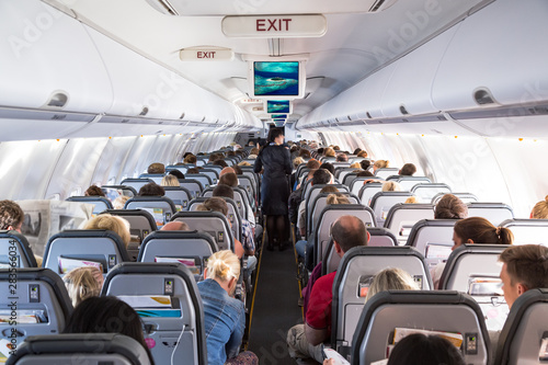 Fotomural Inside view on passenger and cabin crew people on an airline airplane during flight vacation
