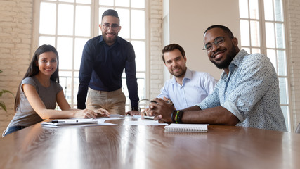 Poster - Happy international professional business team posing together at office table