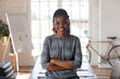 © fizkes - Smiling african female executive standing in modern office, portrait