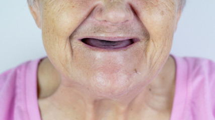 Toothless mouth. An elderly woman with no teeth. Old Granny with her mouth open.