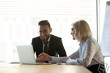 © fizkes - Mature businesswoman mentor helping new employee with corporate software