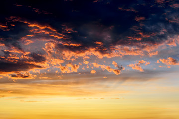Wall Mural - dark thunderclouds with red orange reflections of the setting sun. scenic storm clouds lit by the la