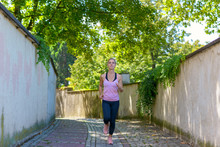 Fit Woman Jogging Down A Leafy Shady Lane