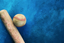 Old Baseball Bat With Ball On Blue Texture Background For Sport Graphic.  Copy Space Beside Vintage Sports Equipment.
