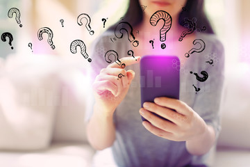Wall Mural - Question marks with woman using her smartphone in a living room