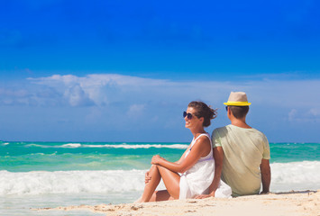 Wall Mural - Beach couple sitting on white sand beach on romantic travel honeymoon vacation summer holidays romance. Young happy lovers, Cayo LArgo, Cuba