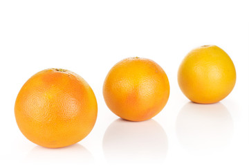 Group of three whole fresh pink grapefruit placed diagonally in line isolated on white background