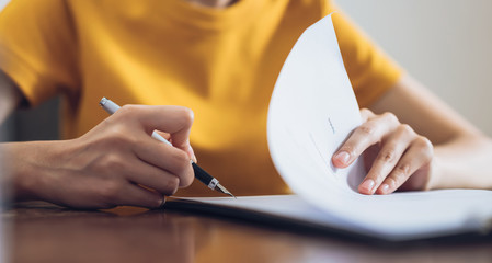 woman signing document and hand holding pen putting signature at paper, order to authorize their rig