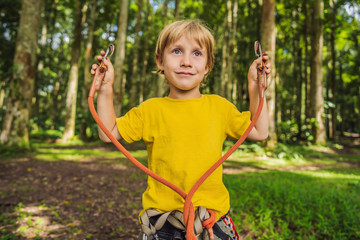 Little boy in a rope park. Active physical recreation of the child in the fresh air in the park. Training for children