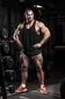 © Fotokvadrat - Muscular athletic bodybuilder man in gym over dark background with dramatic light posing and resting after hard training work out