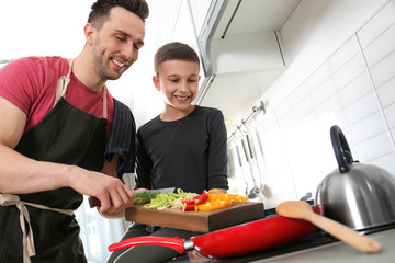 Canvas Print - Dad and son cooking together in kitchen