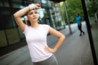 © NDABCREATIVITY - Young happy sporty woman making a break from exercising.