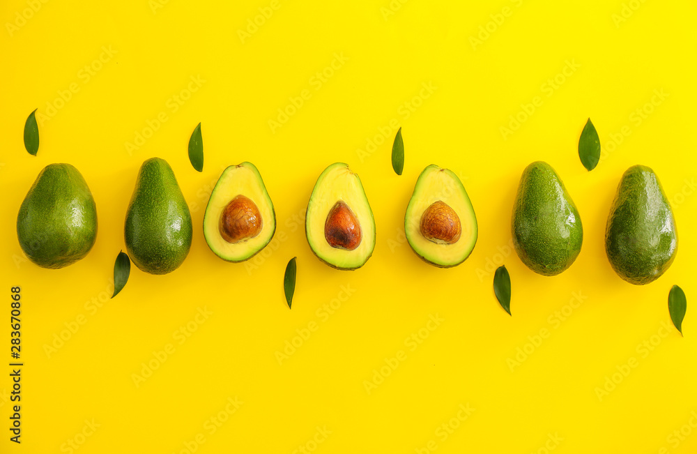 Fresh ripe avocados on color background