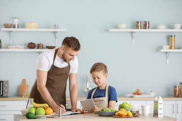 Wall Mural - Portrait of happy father and son cooking in kitchen