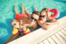 Happy Family In Swimming Pool On Summer Day