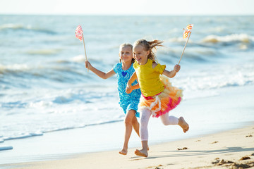 Children at sea. Little girls run on the sea on the waves. 