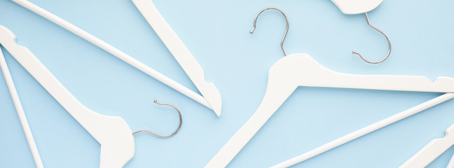 White wooden hangers on blue background