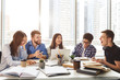 © Prostock-studio - University students sitting together at table with books and laptop