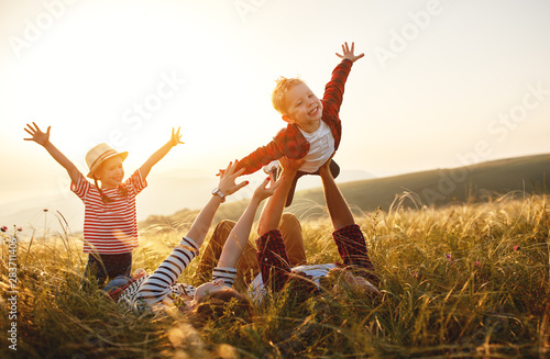 Fotomural Happy family: mother, father, children son and daughter on sunset