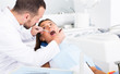 © JackF - Dentist is treating patient which is sitting in dental chair in clinic
