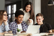 © Prostock-studio - College students using laptop in library, studying together