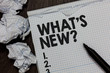 © Artur - Text sign showing What s is New question. Conceptual photo Asking about latest Updates Trends Happening News Marker over notebook crumpled papers ripped pages several tries mistakes