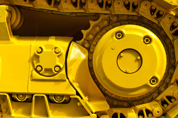 Track drive gear, bulldozer sprocket mechanism, large yellow construction machine with bolts, heavy industry, detail 