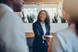 © Flamingo Images - Smiling young African American hotel concierge helping guests ch