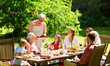 © Syda Productions - leisure, holidays and people concept - happy family having festive dinner or barbecue party at summer garden