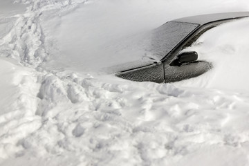 Wall Mural - car under the snow. lots of snow and big snowdrifts on the street. vehicles are completely covered i
